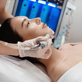 woman reclined receiving cosmetic hydra facial treatment
